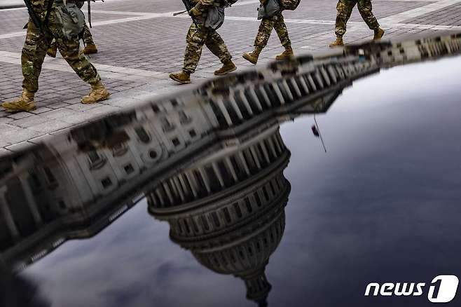 16일(현지시간) 미국 버지니아 주방위군 병사들이 워싱턴DC 의사당 동쪽을 가로질러 감시 초소로 가고 있다. © AFP=뉴스1