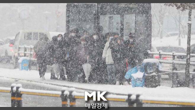 지난 12일 오후 갑자기 눈이 내리고 있는 가운데  서울 연세대 정류장에서 시민 들이  버스를 기다리고 있다 .2021.01.12.이충우기자