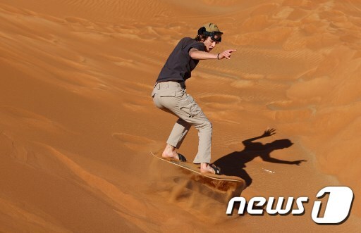 한 관광객이 두바이의 모래사막에서 샌드보딩을 하고 있다. © AFP=뉴스1