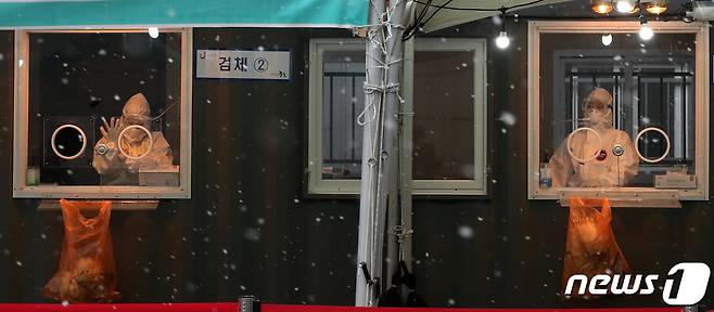 18일 오후 서울역 앞 광장에 마련된 신종 코로나바이러스 감염증(코로나19) 임시선별진료소에서 의료진이 검체를 채취 준비를 하고 있다. 질병관리청 중앙방역대책본부에 따르면 이날 0시 기준 코로나19 신규 확진자는 389명 발생했다. 300명대로 줄어든 것은 지난 11월 25일 이후 54일만이다. 2021.1.18/뉴스1 © News1 김진환 기자