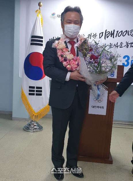 이기흥 후보가 18일 서울 송파구 선거사무실에서 제41대 대한체육회장에 당선이 확정된 뒤 축하 꽃다발을 받고 환하게 웃고 있다.
