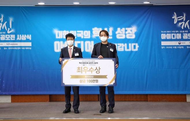 김용래 특허청장(왼쪽)이 15일 서울 강남구 한국지식재산센터에서 열린 특허청 ‘제2차 혁신 아이디어 공모전' 시상식에서 최우수상을 수상한 손아무개씨와 기념촬영을 하고 있다.
