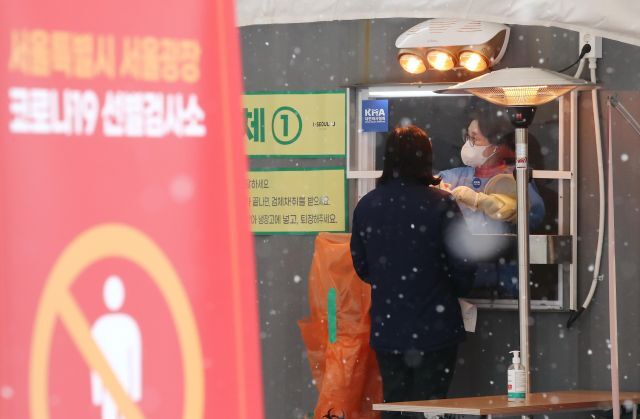 18일 오전 서울광장에 마련된 코로나19 임시 선별검사소에서 의료진이 검체 채취를 하고 있다.  연합