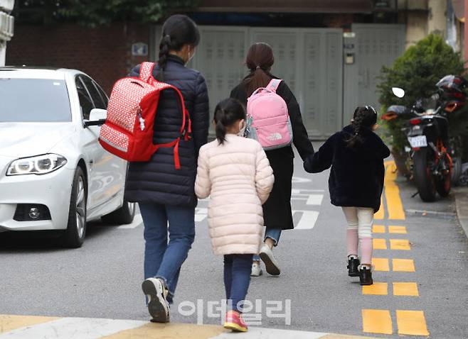 초등학교 돌봄전담사들이 총파업에 들어간 지난해 11월 서울 시내 한 초등학교에서 하교하는 학생들이 마중나온 학부모들과 함께 하교하고 있다.(사진=뉴시스)