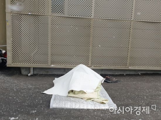 18일 오전 서울 용산구 서울역 광장에서 한 노숙인이 얇은 종이 한 장을 이불삼아 잠을 청하고 있다. 사진=허미담 기자 damdam@asiae.co.kr