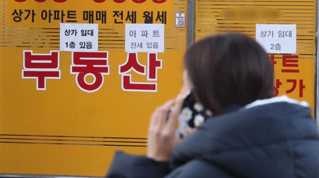 18일 오후 서울 시내의 공인중개사 사무소 앞을 한 시민이 지나고 있다. 뉴스1