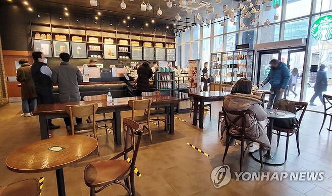 다시 테이블 놓여진 커피전문점 (서울=연합뉴스) 이진욱 기자 = 국내 신종 코로나바이러스 감염증(코로나19) '3차 대유행'의 기세가 한풀 꺾인 가운데 18일부터 카페에서 식당과 마찬가지로 오후 9시까지 매장에서 취식이 허용됐다. 사진은 이날 오후 서울 종로구 한 커피전문점 매장 모습. 2021.1.18 cityboy@yna.co.kr