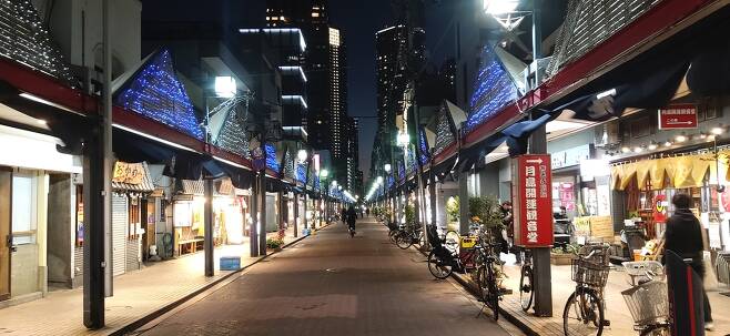 (도쿄=연합뉴스) 코로나19 관련 긴급사태 발효 영향으로 19일 저녁 도쿄 주오(中央)구의 쓰키시마 몬자야키 거리가 한산한 모습이다.