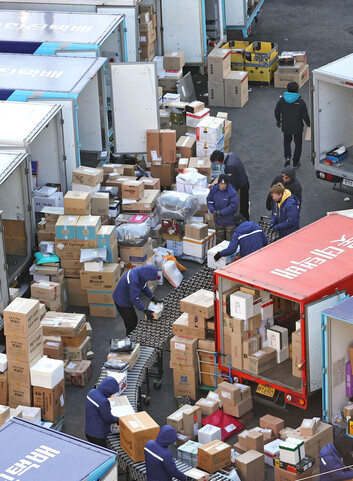 택배노조가 택배회사에 과로사를 막기 위한 대책을 요구하며 협상 결렬시 총파업을 예고한 가운데 19일 오전 서울의 한 택배 물류센터에서 노동자들이 물품을 옮기고 있다. 연합뉴스