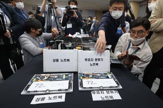 지난해 5월 28일 경기도 과천 중앙선거관리위원회에서 4·15 총선 부정선거 주장에 대한 의혹을 해소하기 위해 열린 '사전투표 및 개표 공개 시연회'에서 관계자들이 투표지 분류기 노트북을 분해하고 있다. 뉴스1
