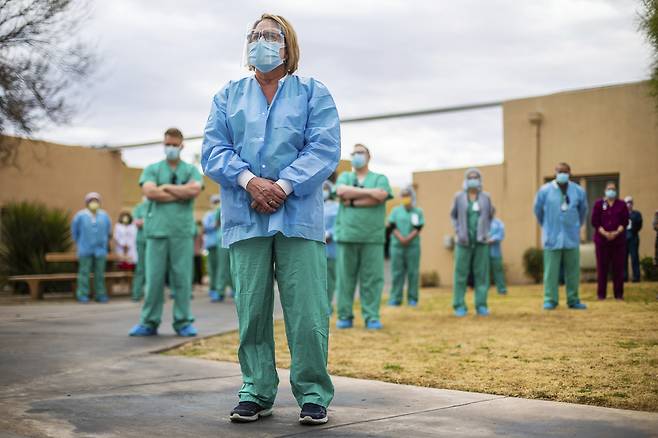 19일(현지시간) 미국 애리조나주 투싼에서 의료진들이 코로나19 사망자를 애도하는 시간을 갖고 있다.[AP]