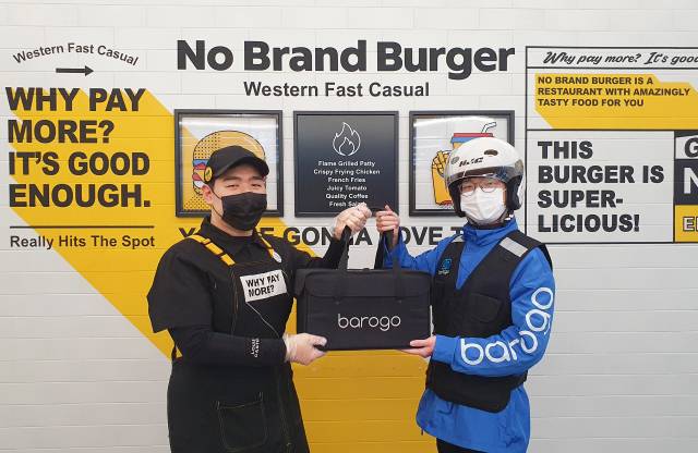 일명 '정용진 버거'로 불리는 노브랜드 버거 직원이 배달 대행업체 바로고의 배달원에게 주문 받은 햄버거를 전달하고 있다. 양사는 20일 배달 대행 계약을 맺었으며 상반기 중 노브랜드 버거 전체 매장에 배달 서비스를 도입할 계획이다. /사진제공=바로고