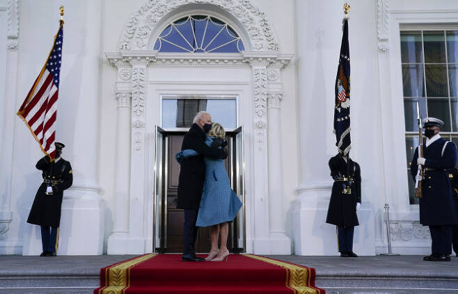 조 바이든 미국 대통령과 질 바이든 여사가 20일(현지시간) 워싱턴DC 연방 의사당에서 열린 공식 취임식을 마친 후 백악관 북쪽 입구인 ‘노스 포르티코’에 도착한 후 포옹하고 있다. (사진=AP/뉴시스 제공)