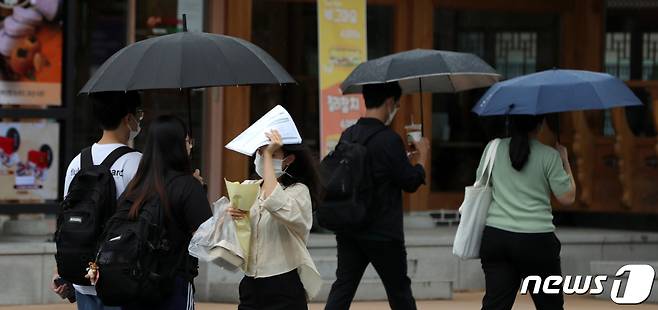17일 전북 전주시 전북대학교에서 빗방울이 떨어지자 우산을 챙기지 못한 시민이 인쇄물로 비를 막으며 발걸음을 재촉하고 있다. 2020.9.17/뉴스1 © News1 유경석 기자