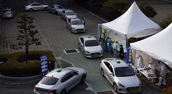 지난 11일 오후 부산 연제구 부산아시아드주경기장 주차장에서 택시 기사들이 드라이브 스루로 코로나19 검사를 받고 있다. 뉴시스