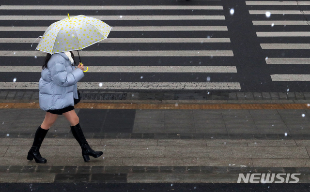[서울=뉴시스]배훈식 기자 = 전국 곳곳에 눈이 예보된 29일 오후 서울 종로구 세종문화회관 인근에서 우산을 쓴 시민이 가는 눈을 맞으며 발걸음을 옮기고 있다. 2020.12.29. dahora83@newsis.com