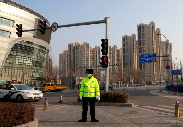 중국이 코로나19 재확산으로 비상인 가운데 지난 20일 코로나19가 발생한 수도 베이징 다싱구의 톈궁위안 지역에서 경찰이 교통을 차단한 채 경비를 서고 있다. /로이터연합뉴스