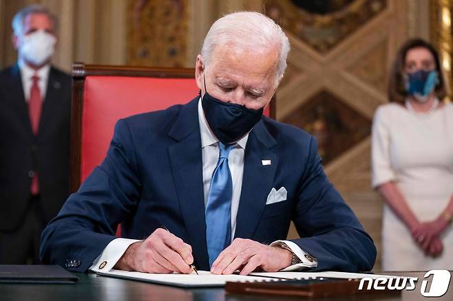 조 바이든 미국 대통령이 20일(현지시간) 워싱턴 백악관에서 취임 후 첫 업무로 파리 기후변화 협약 복귀 등 3건의 행정명령에 서명을 하고 있다. © AFP=뉴스1 © News1 우동명 기자