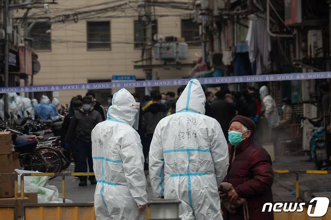 중국 상하이 황푸 지구에서 3명의 코로나19 지역감염자가 발생한 21일, 보호복을 입은 경찰이 주거 지역 출입을 통제하고 있다.  © AFP=뉴스1