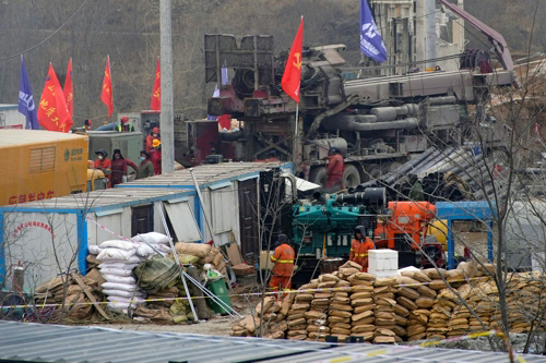 중국 산둥성의 한 금광에서 22일 구조대가 매몰자 구조작업을 하고 있다. 지난 10일 발생한 폭발로 광부 22명이 지하에 매몰된 지 이날로 13일째다. 로이터연합뉴스