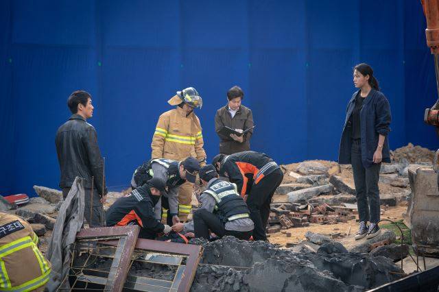 tvN '낮과 밤' 4~5화 중 저택 화재 장면 촬영 모습. 배우 뒤에 놓인 파란 배경이 CG 합성을 위한 크로마 스크린이다. '낮과 밤' 속 건물 붕괴 장면과 화재 전소 장면은 CG팀의 결과물이다. tvN 제공