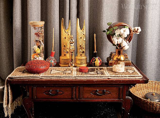 손님방 장식장 위 골드 컬러의 트로피와 목화송이, 인센스가 어우러져 겨울 분위기를 풍긴다.