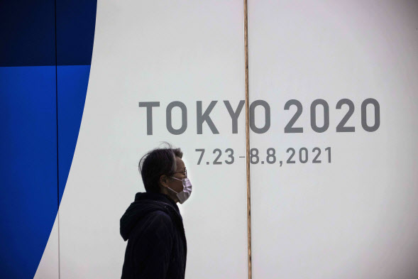 22일 한 시민이 2020 도쿄 올림픽 홍보물 옆을 지나가고 있다. (사진=AFP)