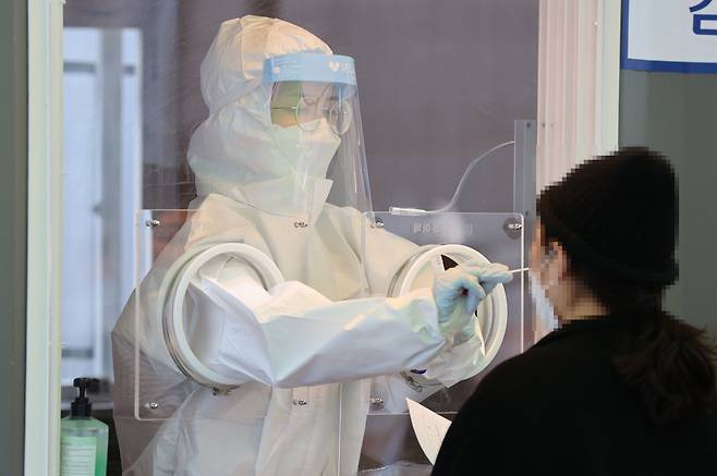 23일 오후 서울역 광장에 마련된 신종 코로나바이러스 감염증(코로나19) 임시 선별 진료소에서 의료진이 검체를 채취하고 있다.[연합]
