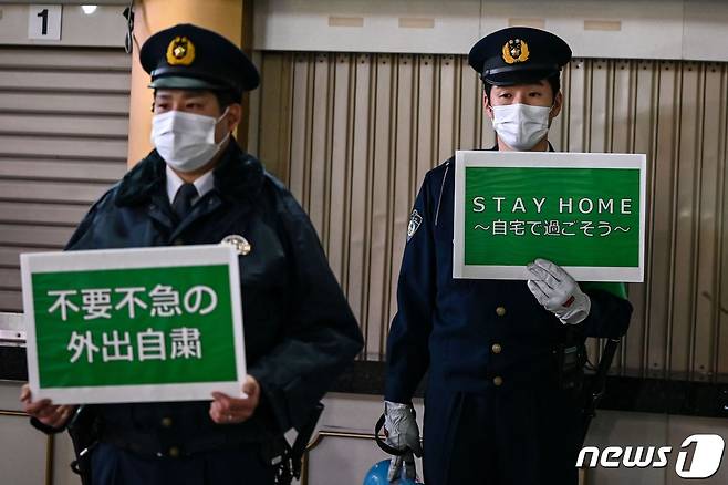 일본 경찰들이 지난 22일 도쿄 시내에서 시민들을 상대로 코로나19 확산 억제를 위한 외출 자제를 호소하고 있다. © AFP=뉴스1