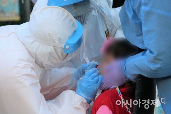 24일 오전 광주광역시 북구 한 어린이집 원아가 코로나19 진단검사를 받고 있다.