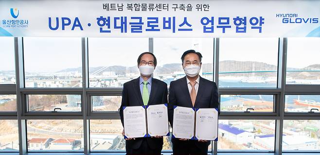 Hyundai Glovis‘ executive vice president Jung Jin-woo (right) poses with his counterpart from Ulsan Port Authority, Jeong Chang-gyu, at an MOU signing ceremony in Ulsan on Jan. 14. (Hyundai Glovis)
