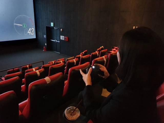 지난 21일 서울 용산 CGV 18관에서 아지트엑스 서비스를 통해 게임을 즐기는 모습. 저작권 문제로 게임 화면은 촬영이 불가능했다. /정혜진 기자