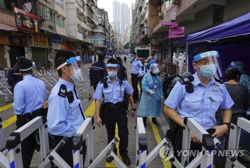 (홍콩 AP=연합뉴스) 홍콩의 도심인 야우마테이 지역이 23일 새벽 신종코로나바이러스감염증(코로나19) 확산억제 대책의 일환으로 전격 봉쇄된 가운데 경찰관들이 도로 통제를 하는 모습.