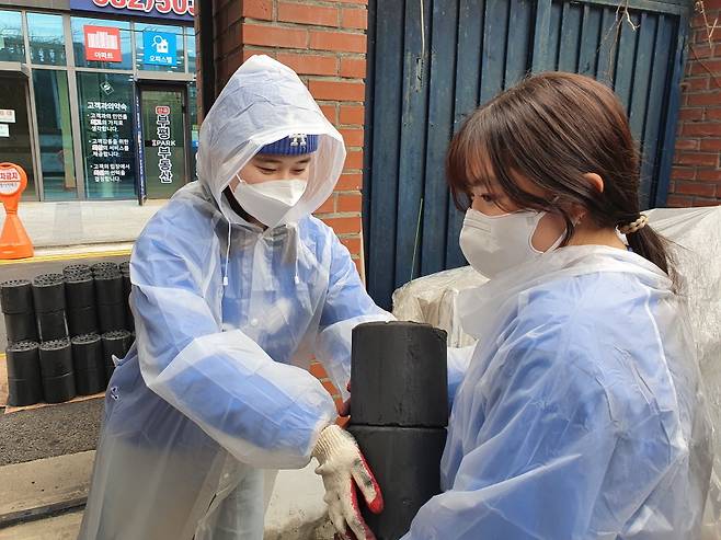 bhc치킨 해바라기 봉사단이 연탄 기부 봉사활동을 진행하고 있다.(bhc치킨 제공) © 뉴스1