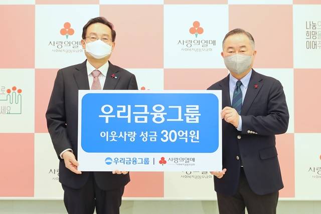 우리금융그룹은 25일 사회복지공동모금회에 성금 30억 원을 기탁했다. 손태승 우리금융그룹 회장(왼쪽)이 예종석 사회복지공동모금회 회장과 기념촬영을 하고 있다. /우리금융 제공