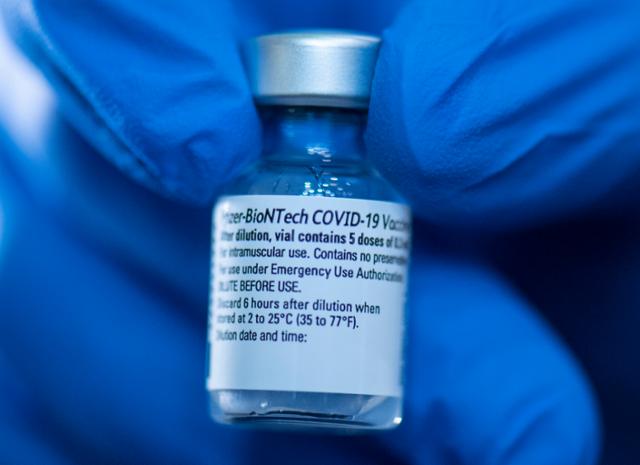 19일(현지시간) 독일의 한 백신 센터에서 의료진이 화이자-비오엔테크 신종 코로나바이러스 감염증(코로나19) 백신 주사약병을 들고 있다. 프랑크푸르트=AP 뉴시스