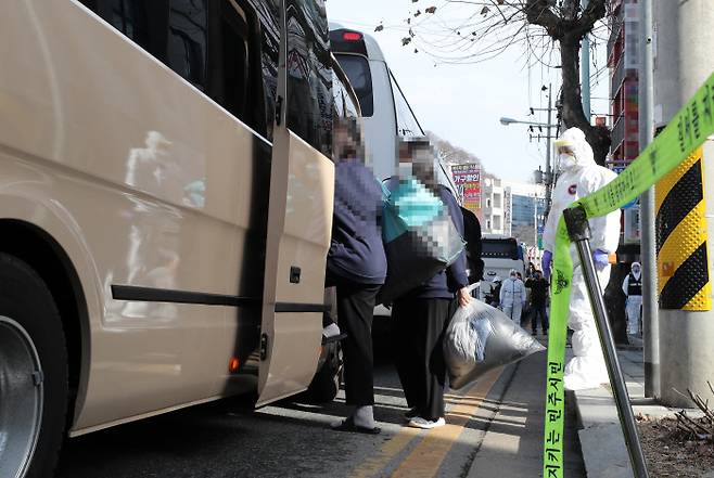 지난 25일 오후 대전시 중구 대흥동 IEM국제학교에서 코로나19 확진자들이 치료센터로 이동하기 위해 차량에 탑승하고 있다. |연합뉴스
