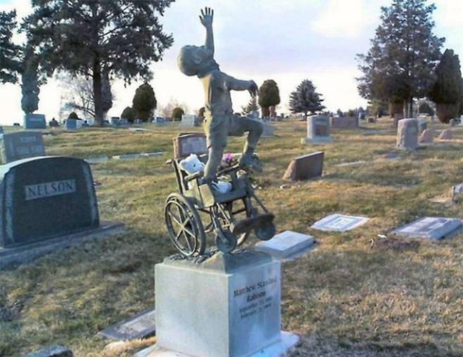 태어나면서 중증 장애를 얻어 휠체어를 사용하다가 11살에 세상을 떠난 매슈 로빈슨의 묘. 매슈의 부모는 아이가 휠체어를 벗어나는 모습을 조각해서 비석 위에 세웠다.