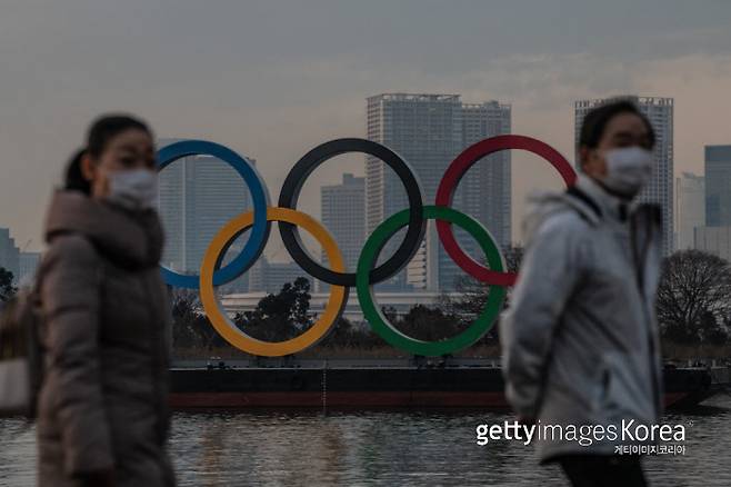일본 도쿄 시민이 지난 22일 마스크를 낀 채 올림픽 오륜기 앞을 지나가고 있다. Getty Images코리아