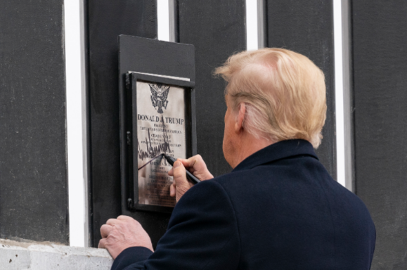 도널드 트럼프 미국 대통령이 텍사스주 알라모의 미국·멕시코 국경장벽을 시찰하며 장벽에 부착된 명판에 서명하고 있다. /연합뉴스