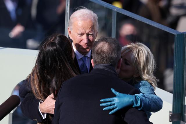 조 바이든 대통령이 20일(현지시간) 미 의회 의사당에서 열린 취임식에서 부인 질 바이든 여사, 아들 헌터 바이든, 딸 애슐리 바이든과 포옹하고 있다. 워싱턴=AP뉴시스