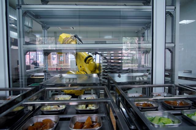 지난달 1일 중국 상하이의 한 고등학교에서 코로나19 감염을 차단하기 위해 로봇이 점심식사를 제조하고 있다. 상하이=로이터 연합뉴스