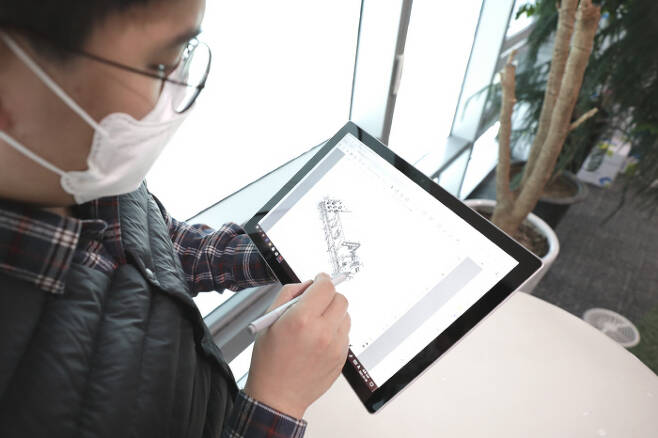 삼성엔지니어링의 한 설계엔지니어가 태블릿PC를 통해 설계도면을 확인하고 있다. [사진 제공 = 삼성엔지니어링]