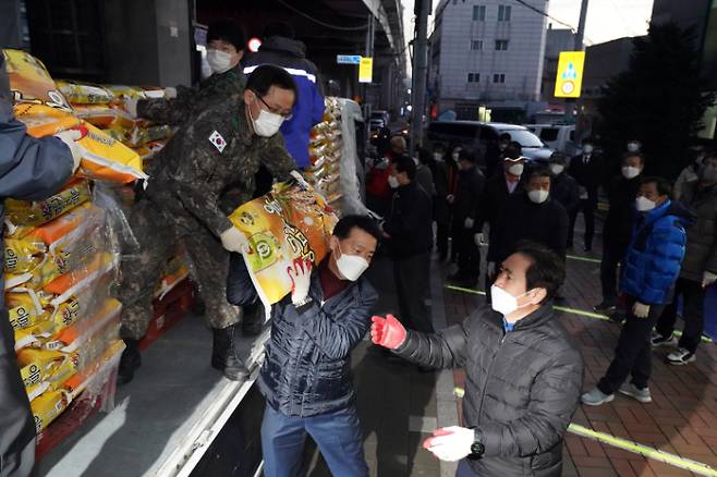 '얼굴 없는 천사'가 올해도 어김없이 서울 성북구 월곡2동 주민센터에 20kg 포장쌀 300포를 보냈다. 2011년 시작해 11년째로 올해까지 총 3300포, 쌀 무게 66톤, 싯가 2억여 원에 이르는 규모다. 27일 새벽 '얼굴 없는 천사'가 보낸 20kg 포장쌀 300포를 실은 트럭이 도착하자 이승로 성북구청장(가운데) 등 관계자들이 쌀포대를 나르고 있다. 성북구 제공