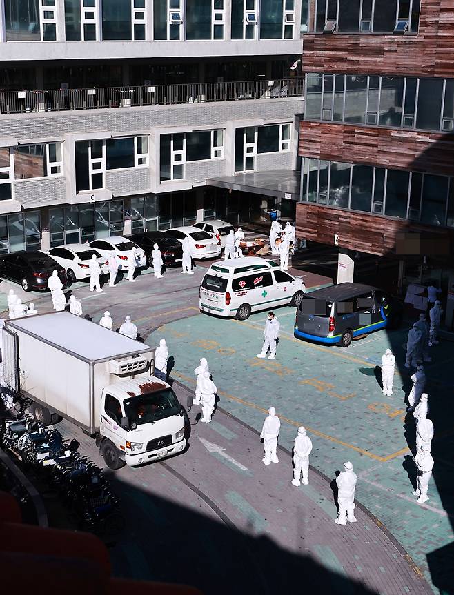 ⓒ연합뉴스2020년 12월30일 서울 구로구의 한 요양병원에서 방호복을 입은 병원 관계자들이 코로나19 검사를 받기 위해 줄 서 있다. 확진자 다수 발생 후 이틀에 한 번씩 검사가 진행된다.
