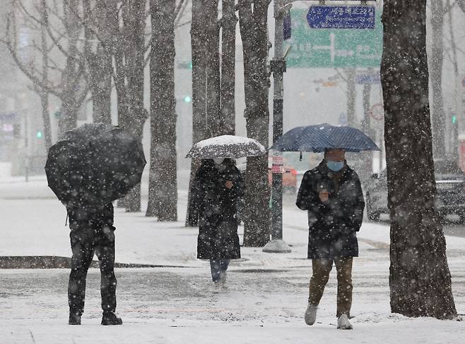 눈이 내린 지난 18일 오전 서울 중구 무교동일대에서 시민들이 눈을 맞으며 걷고 있다. 연합뉴스