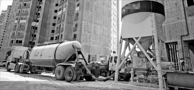 시멘트 육상 운송을 담당하는 벌크시멘트트레일러가 건설현장에 시멘트를 공급하고 있다.  한경DB