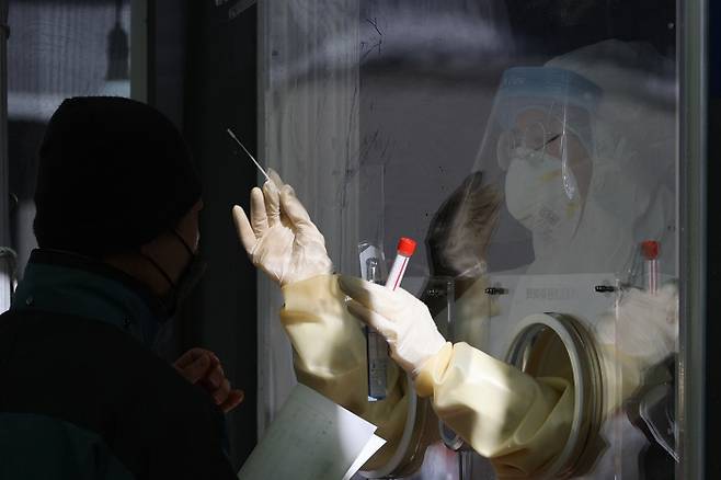 서울역광장에 있는 노숙인시설 ‘서울역 희망지원센터’와 ‘서울역 응급대피소’에서 발생한 코로나19 집단감염이 확산하고 있는 가운데 28일 오후 서울역광장에 설치된 임시선별진료소에서 의료진이 검체채취를 하고 있다.|연합뉴스