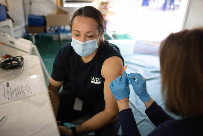 미국의 한 소방관이 코로나 백신을 맞고 있다. [로이터 연합]
