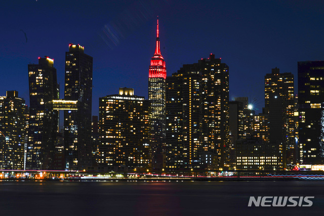 [뉴욕=AP/뉴시스]19일(현지시간) 미국 뉴욕의 엠파이어 스테이트 빌딩 꼭대기에 코로나19 희생자를 추모하는 붉은색 조명이 켜져 있다. 이날 미 전역의 유명 고층빌딩에서 코로나19 희생자를 추모하는 점등식이 열렸다. 미국은 지난해 1월20일 첫 코로나19 확진자가 나온 뒤 1년 만에 사망자 수가 40만 명을 넘어섰다. 2021.01.20.